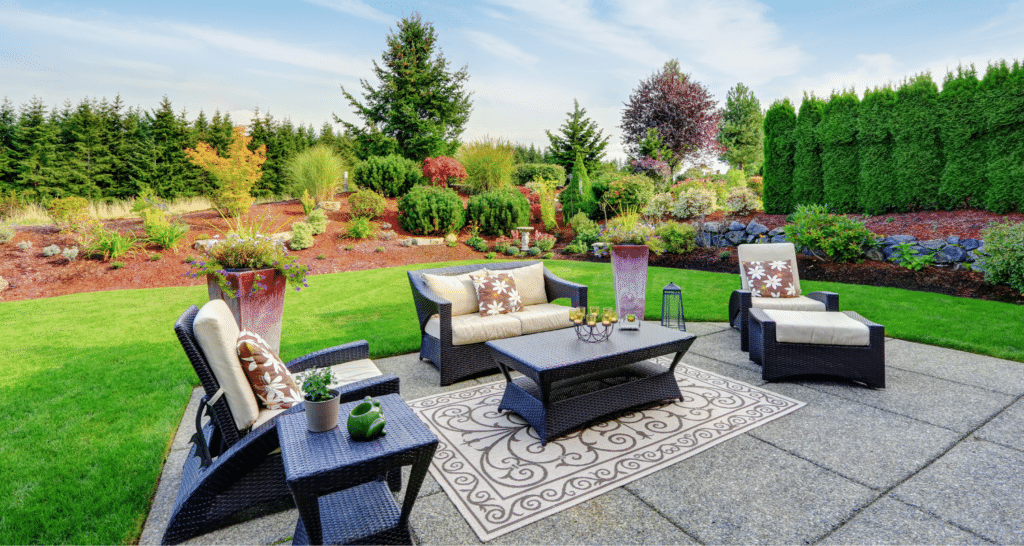 stone patio with seating and a grassy area behind