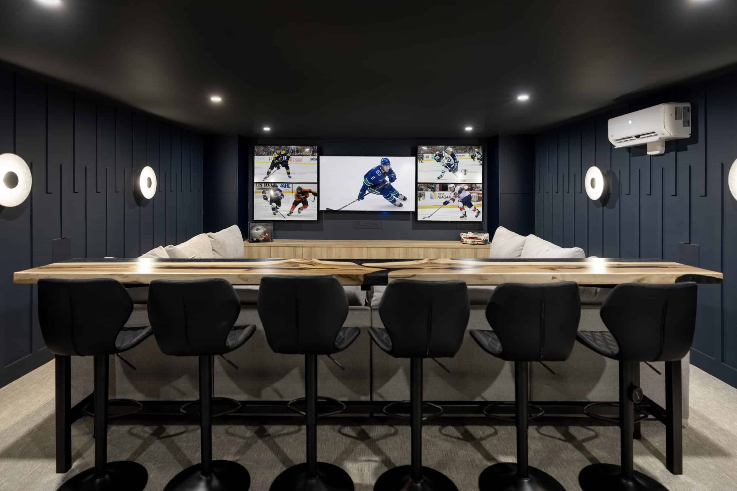 man cave or home theatre with tall bar and multiple tv screens